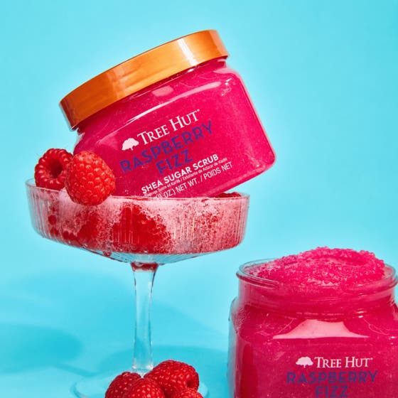 Tree Hut Raspberry Fizz Shea Sugar Scrub 510 g exfolierar huden bland vatten, hallon och Danish Beauty Award-emblem.