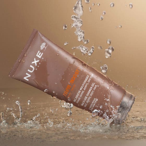 Nuxe Men Multi Shower Gel 200 ml rengörande duschtvål i brun tub omgiven av friska vattenstänk och droppar