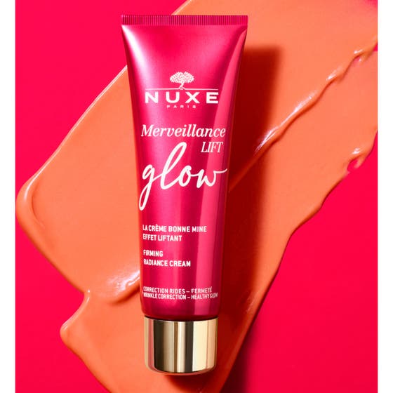 Nuxe Merveillance Lift Glow 50 ml uppstramande kräm ansikte med persikofärgad formula som droppar ur en rosa tub