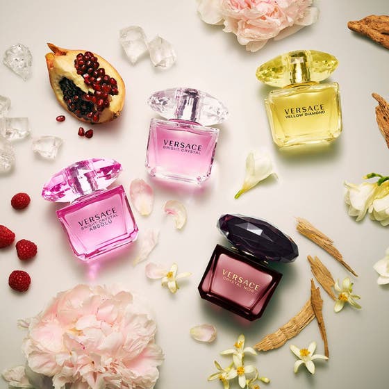Versace Bright Crystal parfymset blommig presentset parfym med flaskor omgivna av granatäpple hallon och pioner
