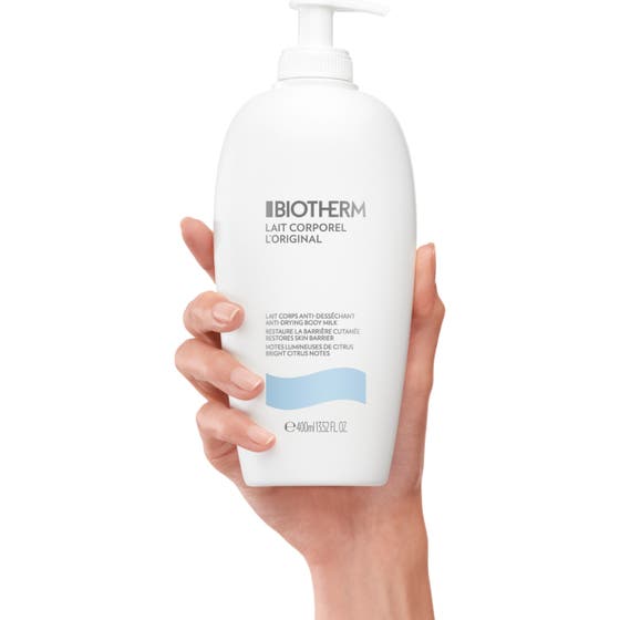 Biotherm Lait Corporel 400 ml anti-uttorkande kroppsmjölk i vit pumpflaska placerad mot en blå himmel