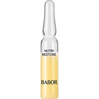 Babor Nutri Restore nutriampull är ett koncentrerat återfuktande serum i en genomskinlig glasampull med gul formula.