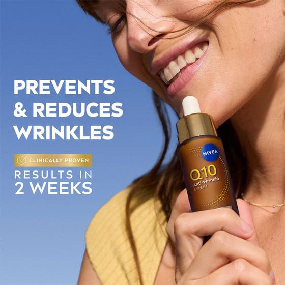NIVEA Q10 Anti-Wrinkle Expert 30 ml serum mot rynkor i brun flaska med pipett och guldlock hålls i en hand