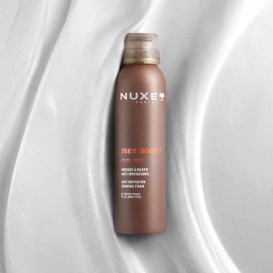 Nuxe Men Shaving Foam 150 ml rakskum som ger en mjuk rakning applicerat som ett vitt fylligt skum på en mans kind
