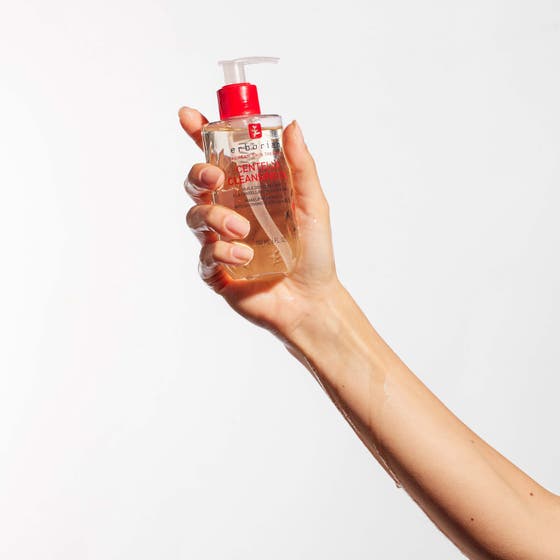 Erborian Centella Cleansing Oil 180 ml centella rengöring i genomskinlig flaska med röd pump som hålls i en hand