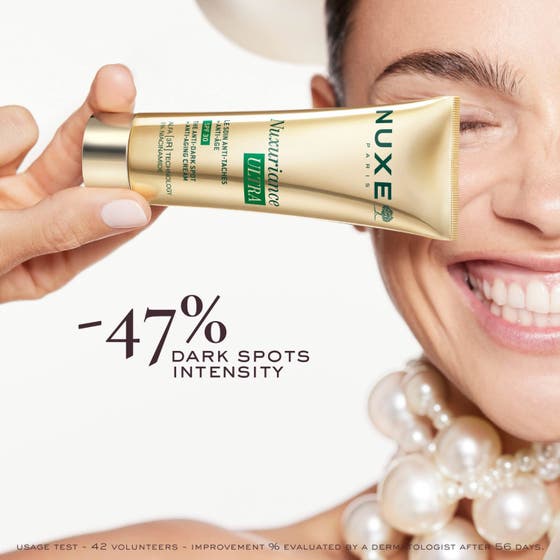 Nuxe Nuxuriance Ultra 50 ml dagkräm mot fläckar med SPF 30 och niacinamide i guldtub framför en krämig klick