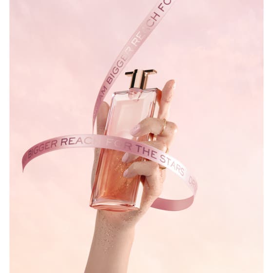 Lancôme Idôle 50 ml blommig elegant parfym i slimmade glasflaskor som svävar fritt mot en rosa himmel