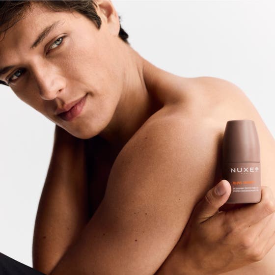Nuxe Men 24Hr Protect Deo 50 ml herrdeodorant i brun förpackning som hålls mot huden för en fräsch känsla.